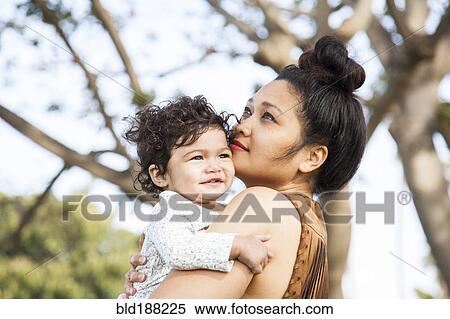 Stock Photography - Mother holding baby son outdoors. Fotosearch