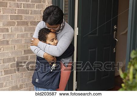 Mother hugging son at front door View Large Photo Image Stock Photo - Mother hugging son at front door. Fotosearch