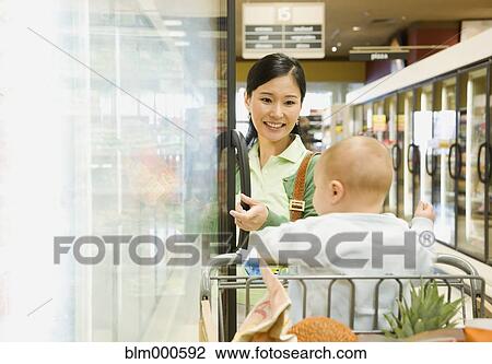 Mother shopping in grocery store with baby View Large Photo Image Stock Image - Mother shopping in grocery store with baby. Fotosearch