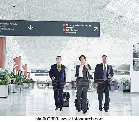 Multi-ethnic business people walking in airport View Large Photo Image Stock Photo - Multi-ethnic business people walking in airport. Fotosearch