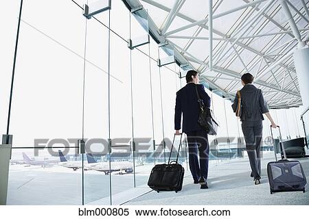 Stock Photography - Multi-ethnic business people walking in airport. Fotosearch