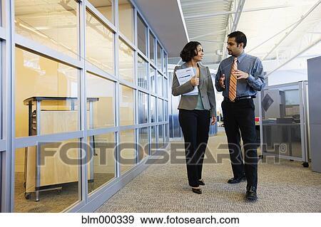 Stock Photo - Multi-ethnic business people walking down office corridor. Fotosearch