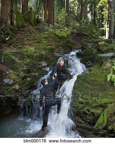 Stock Photograph - Multi-ethnic businessmen climbing up waterfall. Fotosearch