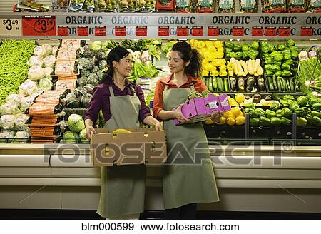 Multi-ethnic co-workers in produce section of grocery store View Large Photo Image Stock Photo - Multi-ethnic co-workers in produce section of grocery store. Fotosearch