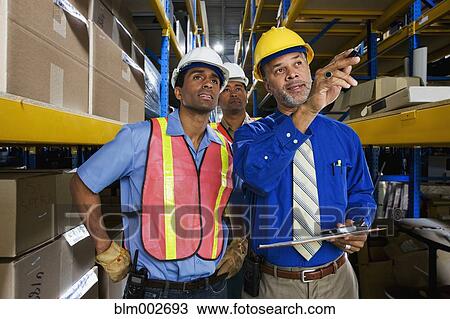 Multi-ethnic co-workers in warehouse View Large Photo Image Stock Image - Multi-ethnic co-workers in warehouse. Fotosearch