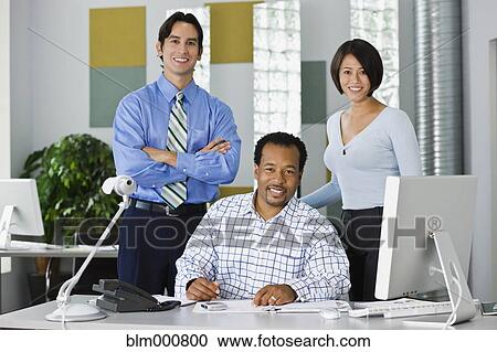 Stock Image - Multi-ethnic co-workers working in office. Fotosearch