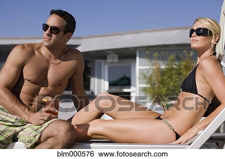 Multi-ethnic couple drinking cocktails poolside View Large Photo Image Stock Photograph - Multi-ethnic couple drinking cocktails poolside. Fotosearch