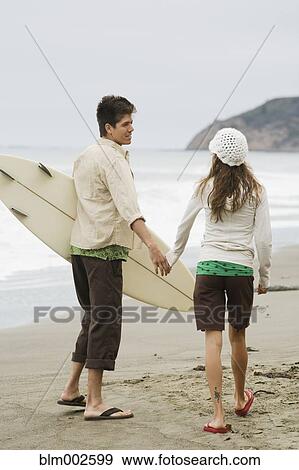 Multi-ethnic couple holding hands at beach View Large Photo Image Stock Photo - Multi-ethnic couple holding hands at beach. Fotosearch