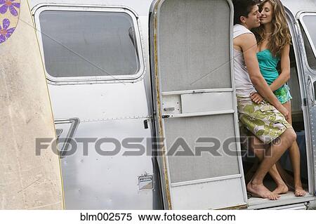 Stock Photography - Multi-ethnic couple hugging in doorway of camper. Fotosearch