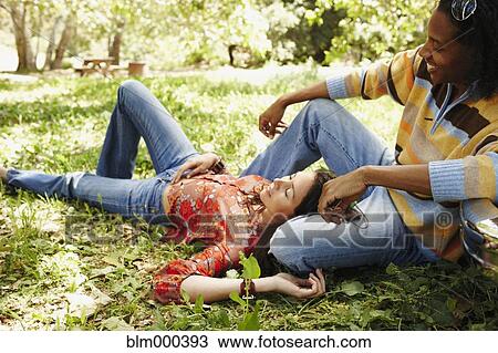 Multi-ethnic couple relaxing outdoors View Large Photo Image Stock Image - Multi-ethnic couple relaxing outdoors. Fotosearch