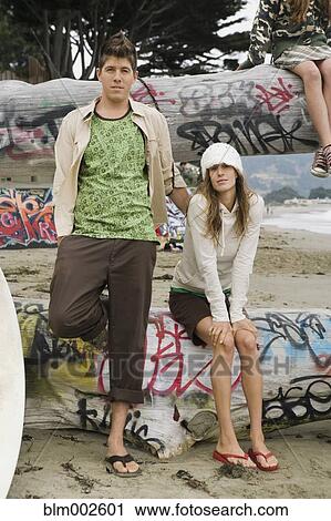 Multi-ethnic couple sitting on graffiti logs View Large Photo Image Stock Image - Multi-ethnic couple sitting on graffiti logs. Fotosearch