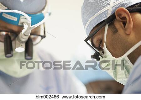 Stock Photograph - Multi-ethnic doctors wearing magnifying glasses. Fotosearch