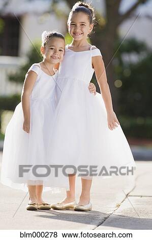 Stock Photo - Multi-ethnic flower girls hugging. Fotosearch