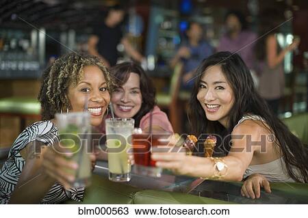 Multi-ethnic friends drinking cocktails in nightclub View Large Photo Image Stock Image - Multi-ethnic friends drinking cocktails in nightclub. Fotosearch