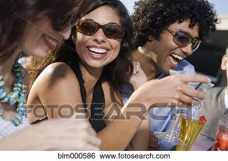 Stock Photograph - Multi-ethnic friends drinking cocktails. Fotosearch
