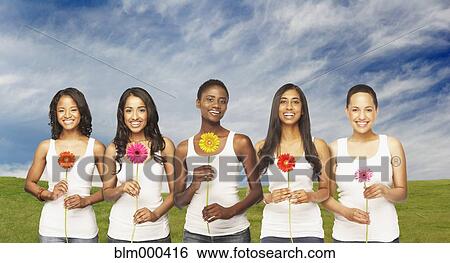 Stock Photograph - Multi-ethnic friends holding daisies. Fotosearch