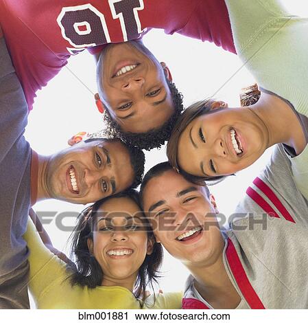 Stock Image - Multi-ethnic friends in huddle. Fotosearch