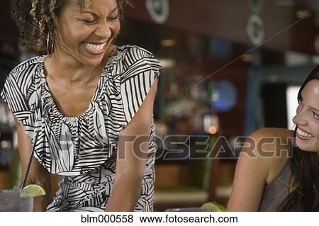 Stock Photo - Multi-ethnic friends laughing in nightclub. Fotosearch