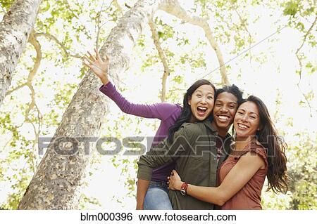 Stock Photograph - Multi-ethnic friends laughing outdoors. Fotosearch