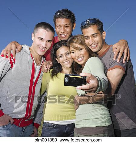 Stock Image - Multi-ethnic friends taking own photograph. Fotosearch