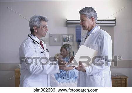 Multi-ethnic male doctors discussing patient View Large Photo Image Stock Photograph - Multi-ethnic male doctors discussing patient. Fotosearch