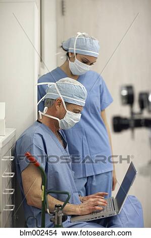 Picture - Multi-ethnic medical professionals looking at laptop. Fotosearch