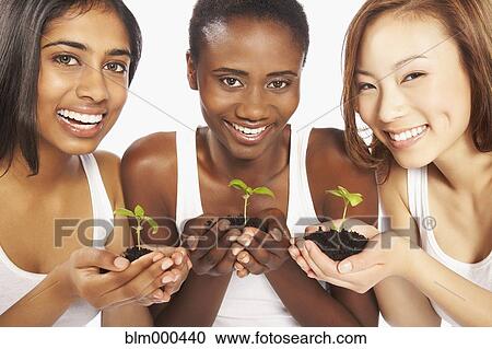 Multi-ethnic women holding soil and seedlings View Large Photo Image Stock Image - Multi-ethnic women holding soil and seedlings. Fotosearch