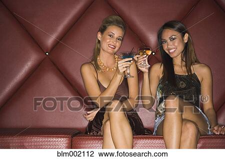 Stock Image - Multi-ethnic women toasting with cocktails. Fotosearch