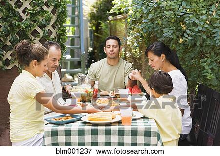 Multi-generational Hispanic family eating on patio View Large Photo Image Stock Photo - Multi-generational Hispanic family eating on patio. Fotosearch