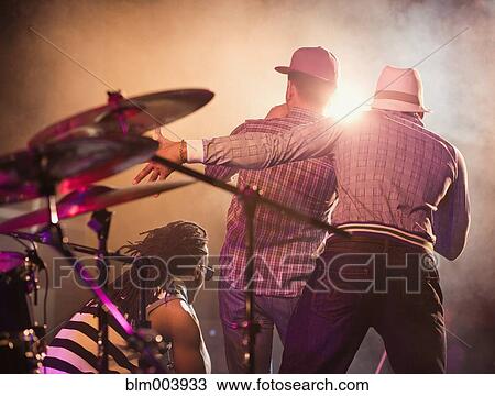 Stock Image - Musical group performing onstage. Fotosearch