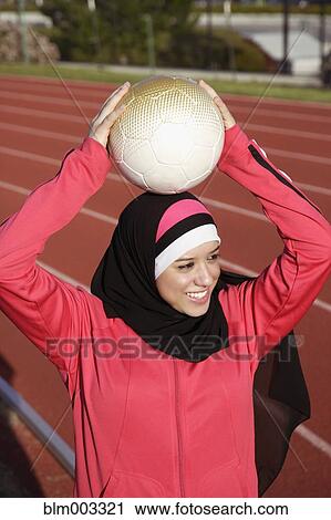 Stock Image - Muslim teenager holding soccer ball. Fotosearch