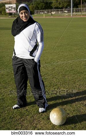 Stock Photograph - Muslim teenager standing with soccer ball. Fotosearch