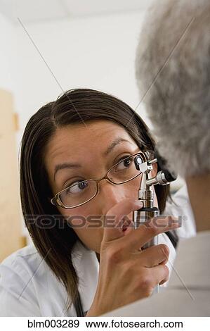 Stock Photo - Native American doctor examining patient's ear. Fotosearch