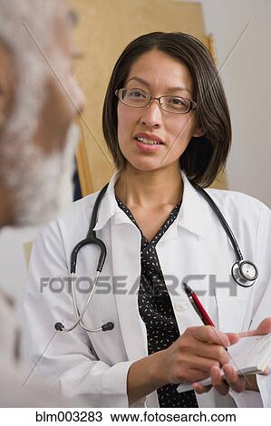 Stock Image - Native American doctor writing prescription. Fotosearch