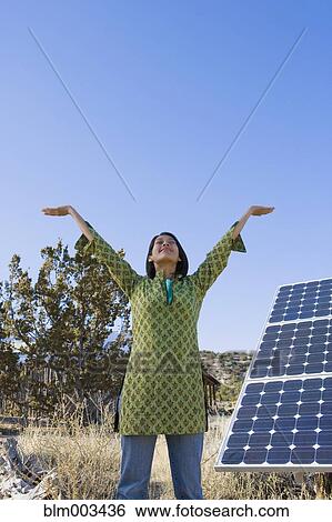 Stock Photograph - Native American woman stretching near solar panels. Fotosearch
