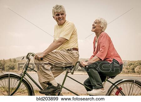 Older Caucasian couple riding tandem bicycle View Large Photo Image Stock Photo - Older Caucasian couple riding tandem bicycle. Fotosearch