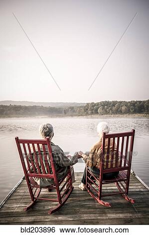 Older Caucasian couple sitting on wooden dock View Large Photo Image Stock Photograph - Older Caucasian couple sitting on wooden dock. Fotosearch