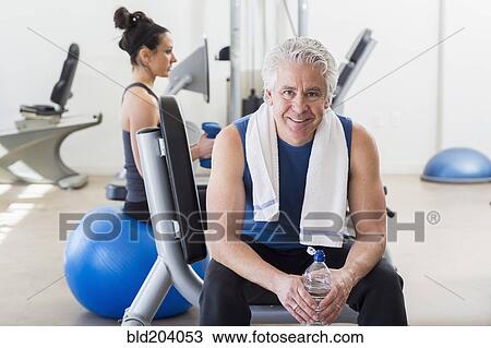 Stock Image - Older Hispanic man smiling in gym. Fotosearch