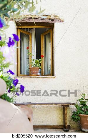 Stock Image - Open Window With Potted Plant and Bench. Fotosearch