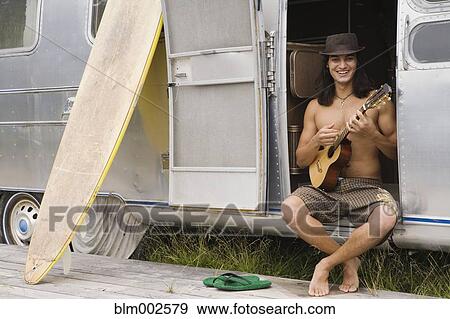 Stock Photo - Pacific Islander man playing ukulele. Fotosearch