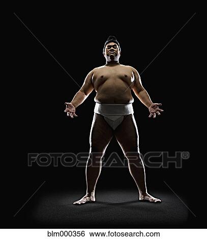 Stock Photograph - Pacific Islander sumo wrestler standing with open hands. Fotosearch