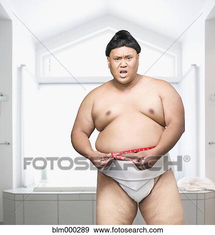 Stock Photo - Pacific Islander sumo wrestler measuring waistline. Fotosearch