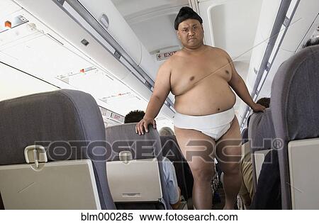 Pacific Islander sumo wrestler walking down airplane aisle View Large Photo Image Stock Photography - Pacific Islander sumo wrestler walking down airplane aisle. Fotosearch