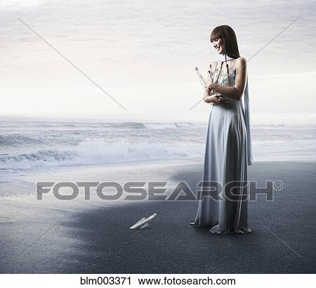 Stock Image - Pacific Islander woman gathering bottles with messages. Fotosearch