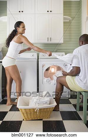 Stock Photo - Playful couple folding laundry. Fotosearch
