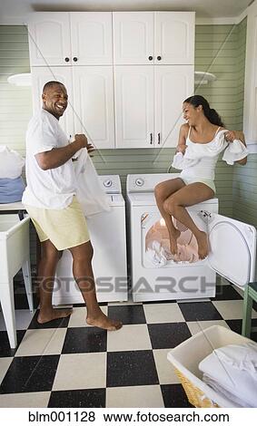 Stock Photo - Playful couple folding laundry. Fotosearch