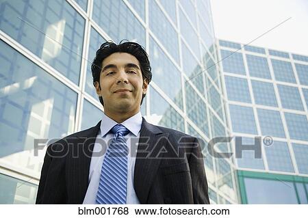 Stock Photo - Portrait of Hispanic businessman in urban scene. Fotosearch