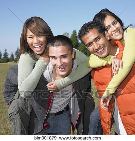 Stock Photo - Portrait of multi-ethnic couples in field. Fotosearch