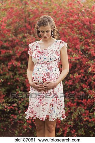 Pregnant Caucasian woman holding her belly outdoors View Large Photo Image Stock Image - Pregnant Caucasian woman holding her belly outdoors. Fotosearch