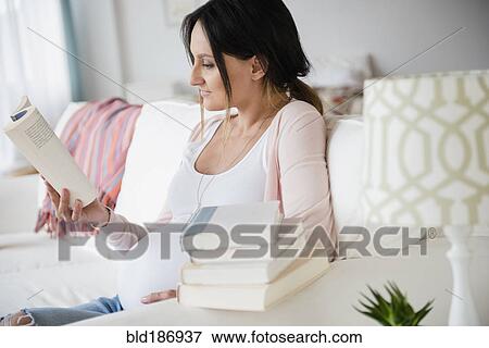 Pregnant Caucasian woman reading baby books View Large Photo Image Stock Photo - Pregnant Caucasian woman reading baby books. Fotosearch